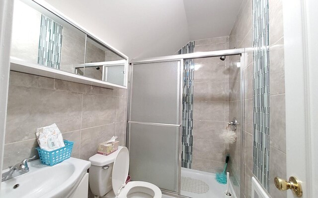 8 Lemberg Ct Unit 302, Monroe, NY 10950 - bathroom with a sink, lofted ceiling, a shower stall, toilet, and tile walls