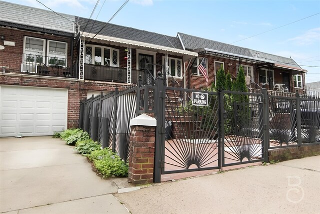 20-21 48th St, Astoria, NY 11105 - view of property with brick siding, a fenced front yard, a garage, and driveway