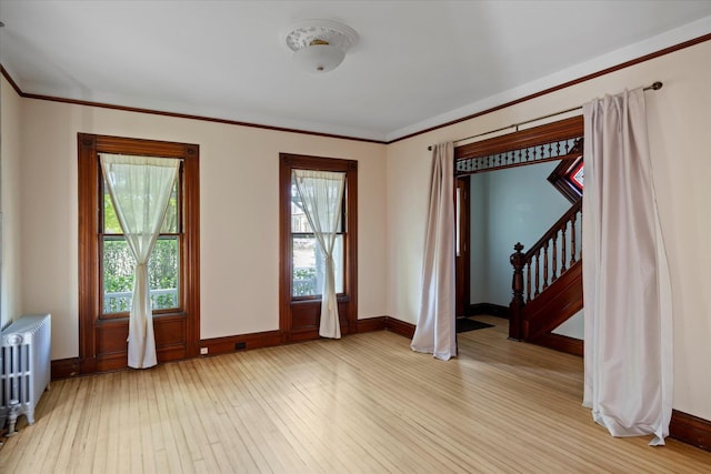 604 Main St, Greenport, NY 11944 - unfurnished room featuring radiator heating unit, light wood finished floors, baseboards, and crown molding