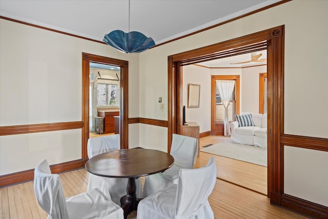 604 Main St, Greenport, NY 11944 - dining room with light wood-type flooring, crown molding, and baseboards