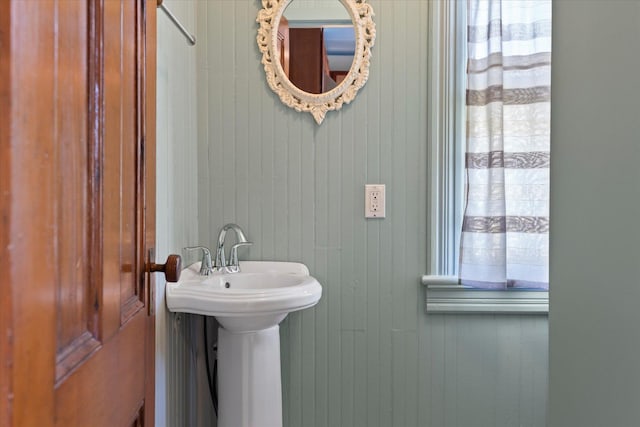 604 Main St, Greenport, NY 11944 - half bathroom featuring wood walls and a sink