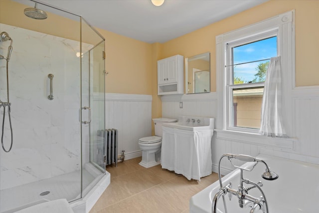 604 Main St, Greenport, NY 11944 - bathroom featuring radiator heating unit, a marble finish shower, plenty of natural light, wainscoting, and a garden tub