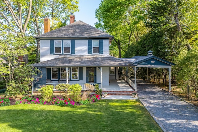 view of front of home featuring a chimney, a porch, asphalt driveway, a front yard, and roof with shingles