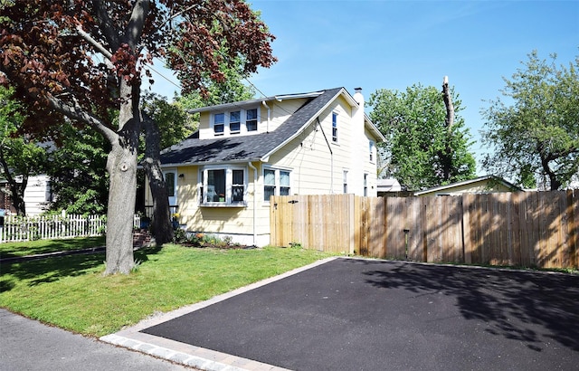 view of front of house featuring a chimney and a shingled roof