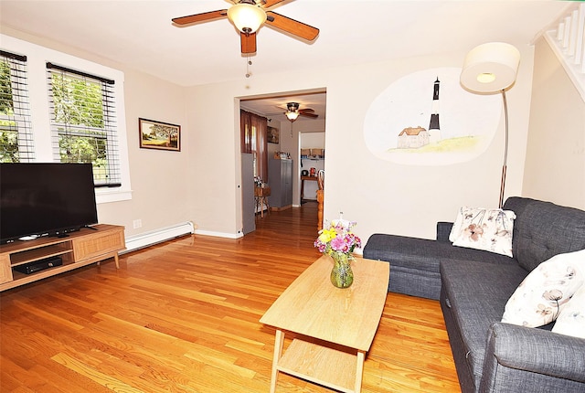 living room featuring a ceiling fan, baseboard heating, wood finished floors, and baseboards