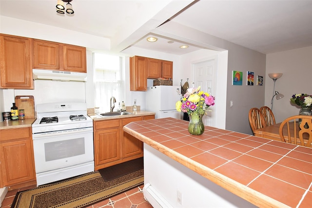 kitchen featuring white appliances, under cabinet range hood, a sink, tile countertops, and recessed lighting