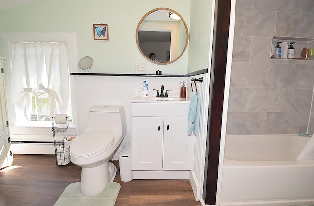 bathroom with wood finished floors, a baseboard radiator, vanity, toilet, and a wainscoted wall