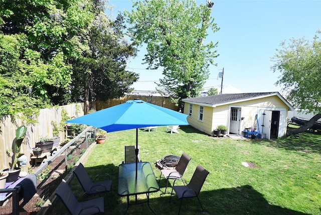view of yard featuring an outbuilding and a fire pit