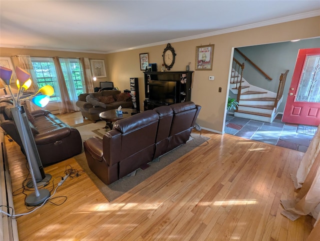 living room with wood finished floors, crown molding, stairway, and baseboards