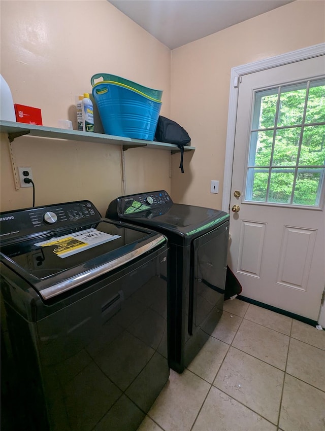 laundry area with separate washer and dryer and light tile patterned floors