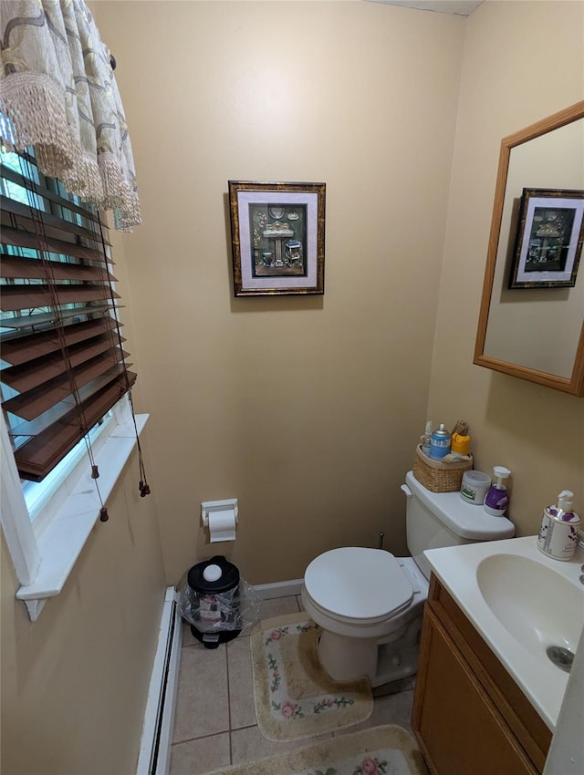 half bath featuring toilet, tile patterned flooring, vanity, a baseboard radiator, and baseboards