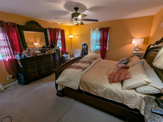 bedroom featuring multiple windows, carpet floors, a baseboard heating unit, and ceiling fan