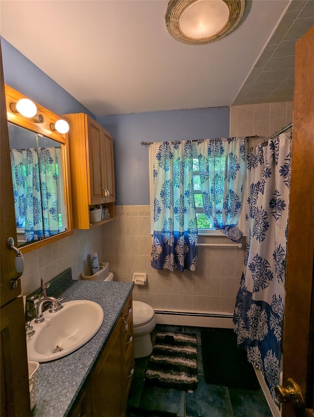 bathroom with a baseboard radiator, tile walls, vanity, toilet, and curtained shower