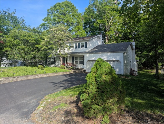 view of front facade featuring a garage, asphalt driveway, and a chimney