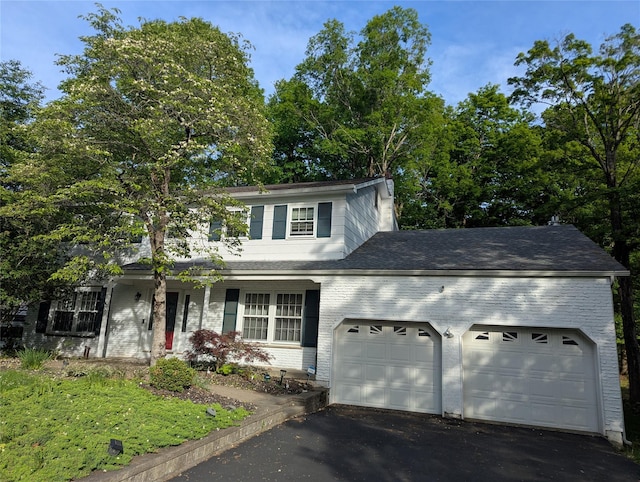 traditional home with an attached garage, driveway, brick siding, a porch, and a shingled roof