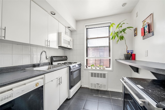 100-25 Queens Blvd Unit 6E, Forest Hills, NY 11375 - kitchen featuring white appliances, radiator heating unit, a sink, white cabinetry, and tasteful backsplash