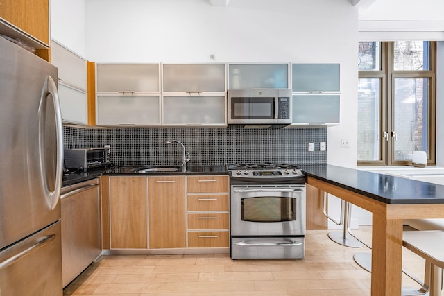 242 S 1st St Unit 1D, Brooklyn, NY 11211 - kitchen featuring stainless steel appliances, tasteful backsplash, light wood-style floors, and modern cabinets