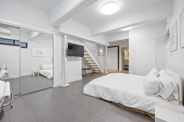 242 S 1st St Unit 1D, Brooklyn, NY 11211 - bedroom featuring a wall unit AC, tile patterned floors, beamed ceiling, and baseboards