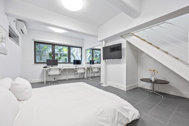 242 S 1st St Unit 1D, Brooklyn, NY 11211 - bedroom with a wall mounted AC, dark tile patterned floors, baseboards, and a desk
