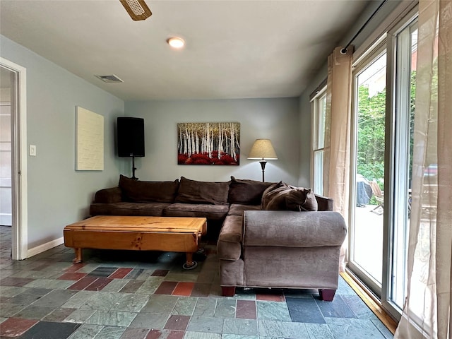 living area featuring stone tile flooring and baseboards