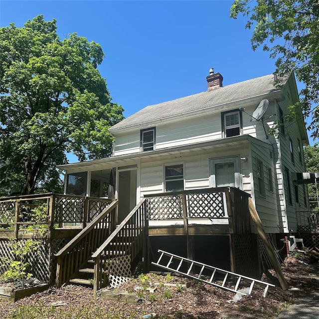 back of house featuring a chimney and stairway