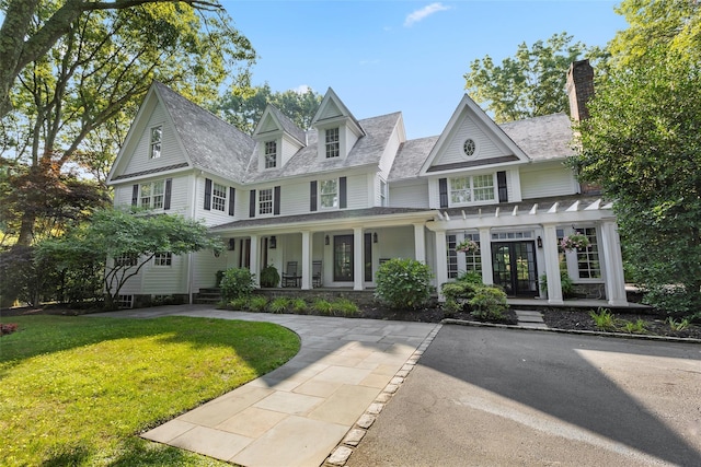 view of front facade featuring covered porch, a pergola, a front lawn, and a chimney