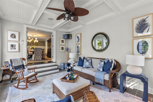 living area with coffered ceiling, a chandelier, a ceiling fan, beamed ceiling, and baseboards