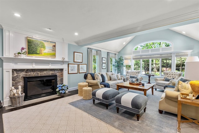 living area featuring vaulted ceiling, a stone fireplace, recessed lighting, baseboards, and wood finished floors