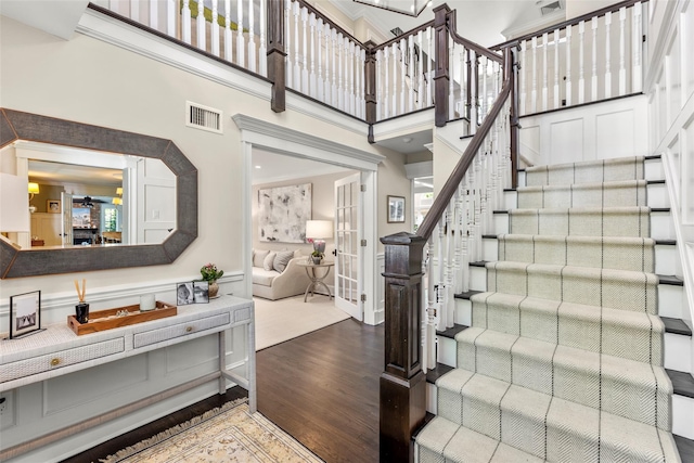 stairs with wood finished floors and a high ceiling