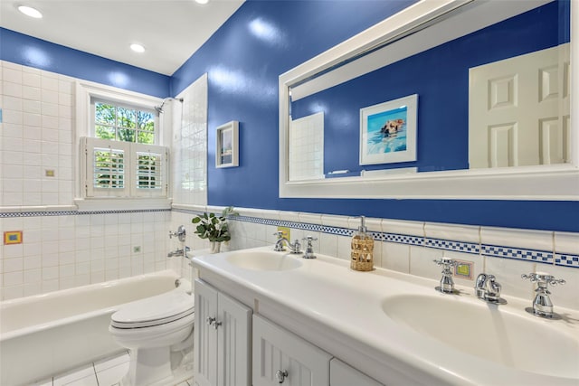 bathroom with tile walls, tile patterned floors, toilet, double vanity, and recessed lighting