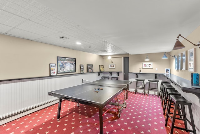 recreation room with a dry bar and carpet flooring