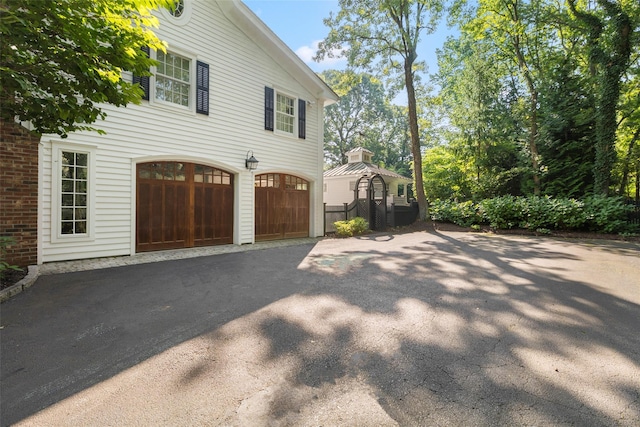 view of side of home with an attached garage and driveway