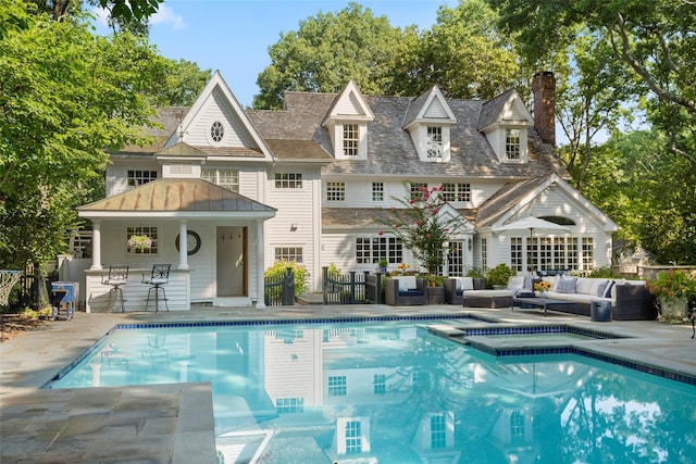 view of pool with an outdoor hangout area, a patio, a pool with connected hot tub, and fence