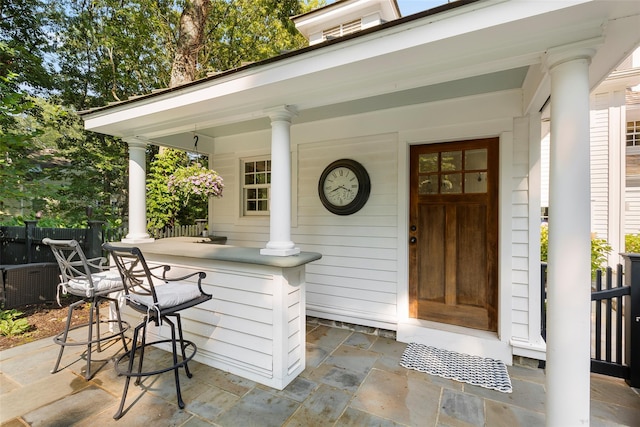 property entrance with fence and covered porch