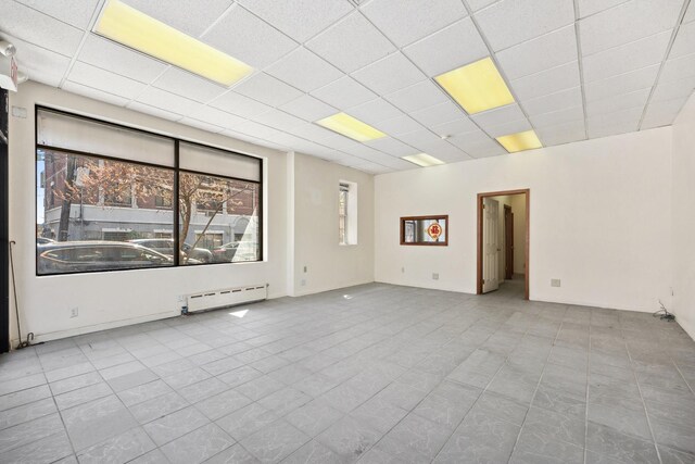 42-06 66th St, Woodside, NY 11377 - tiled empty room featuring a baseboard radiator and a paneled ceiling
