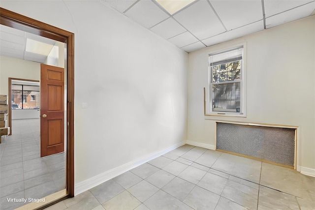 42-06 66th St, Woodside, NY 11377 - empty room with light tile patterned flooring, healthy amount of natural light, baseboards, and a drop ceiling