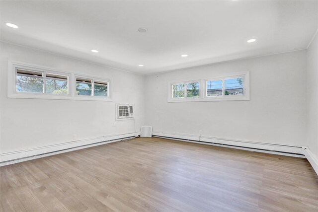 spare room featuring a baseboard heating unit, wood finished floors, and recessed lighting