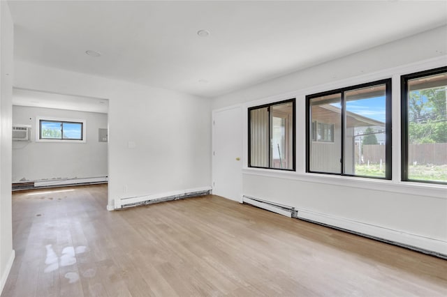 spare room with a baseboard heating unit and wood finished floors