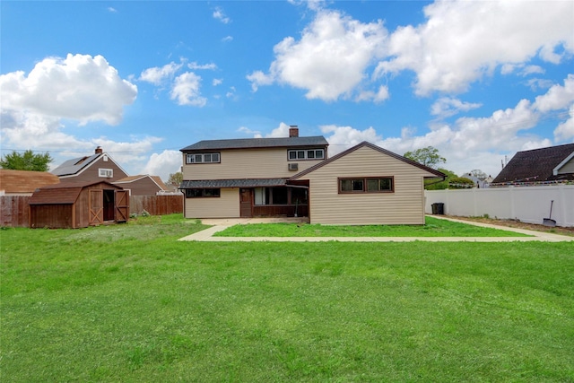 back of house featuring a shed, an outdoor structure, and a patio area