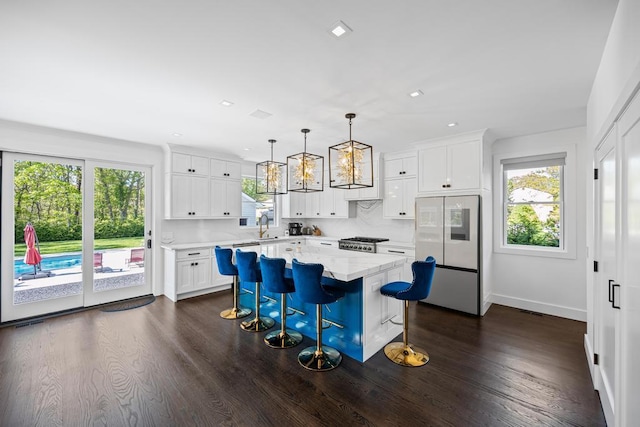 128 Priscilla Ave, Flanders, NY 11901 - kitchen with plenty of natural light, dark wood-type flooring, a kitchen island, a breakfast bar, and recessed lighting