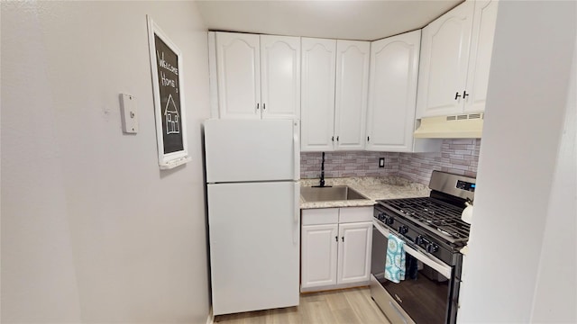 35 Navajo Ct Unit 35, Coram, NY 11727 - kitchen featuring freestanding refrigerator, gas range, under cabinet range hood, a sink, and white cabinetry