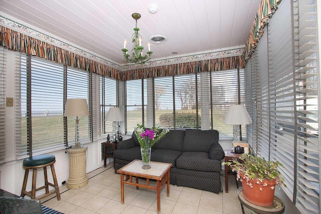 sunroom with healthy amount of natural light, an outdoor living space, and a chandelier