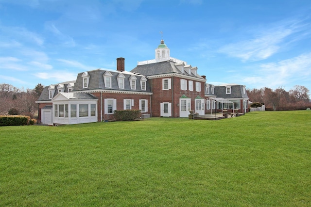 2 Wallis Ln, Nissequogue, NY 11780 - back of property featuring a sunroom, a yard, a chimney, and brick siding