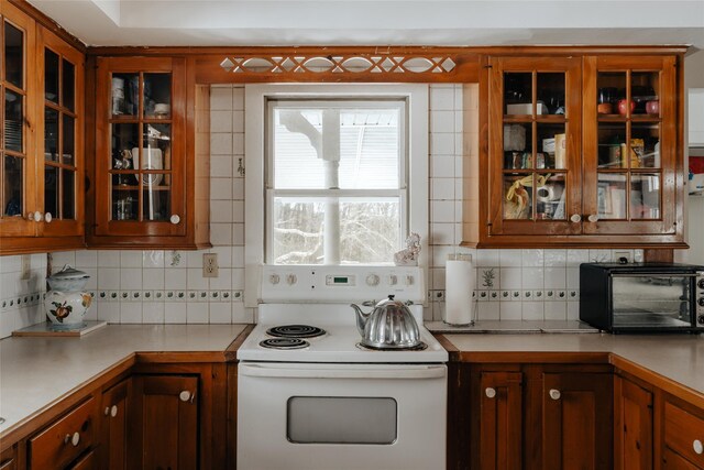 26 Beckys Hill Rd, Hurleyville, NY 12747 - kitchen with electric range, decorative backsplash, light countertops, and glass insert cabinets