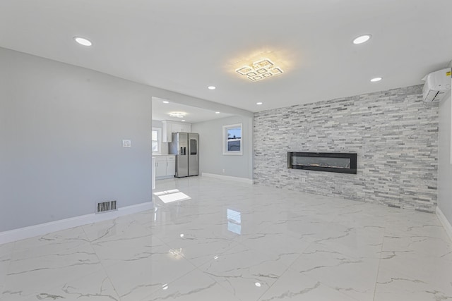 52 State St, Valley Stream, NY 11580 - unfurnished living room featuring a wall mounted air conditioner, baseboards, a large fireplace, light marble finish floors, and recessed lighting