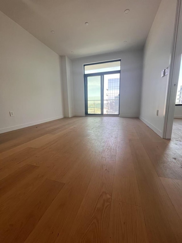 spare room with light wood-style floors and baseboards