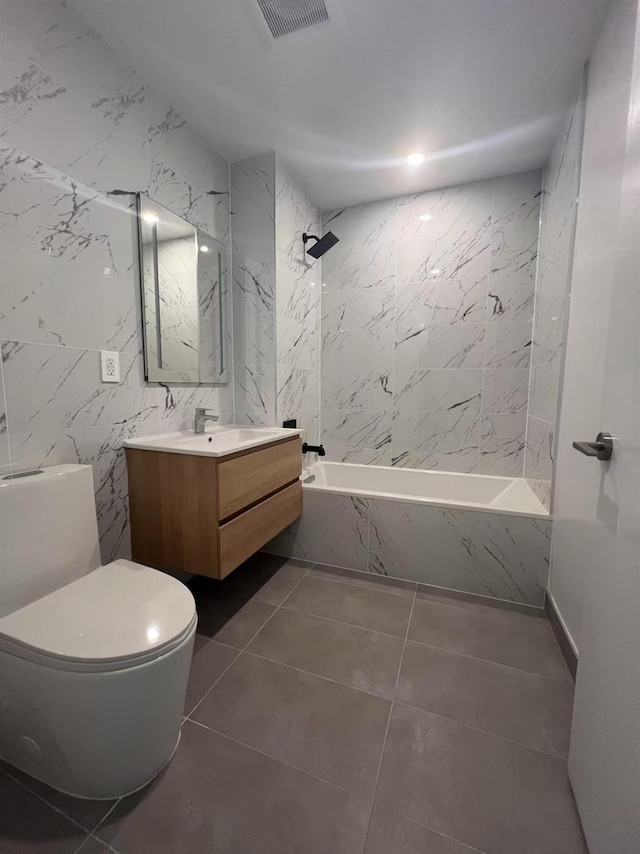 bathroom featuring a combined bath / shower with marble appearance, tile walls, toilet, vanity, and tile patterned floors