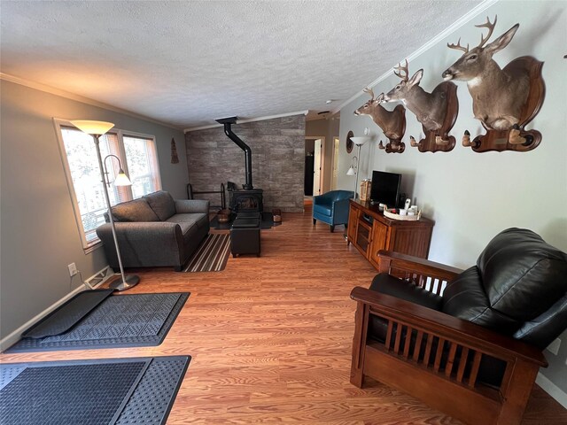 265 Old Tacy Rd Unit Tr95, Swan Lake, NY 12783 - living area with a textured ceiling, a wood stove, ornamental molding, and light wood-style floors