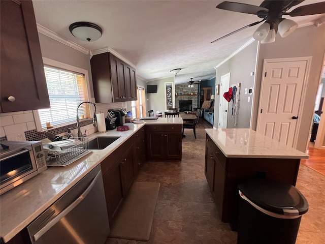 265 Old Tacy Rd Unit Tr95, Swan Lake, NY 12783 - kitchen featuring a sink, appliances with stainless steel finishes, a large fireplace, crown molding, and a ceiling fan