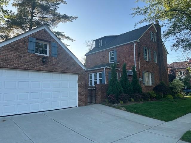 163-18 Cryders Ln, Whitestone, NY 11357 - traditional home with brick siding, a garage, and concrete driveway